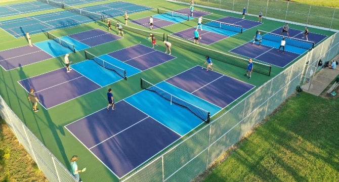 Outdoor pickleball courts with pickleball players